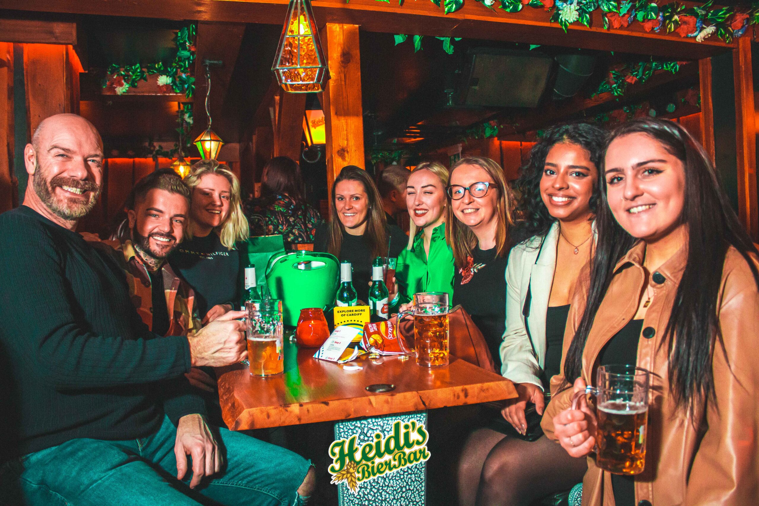 heidis bier bar launch night - 8 guests seated at a booth enjoying beer and smiling at the camera