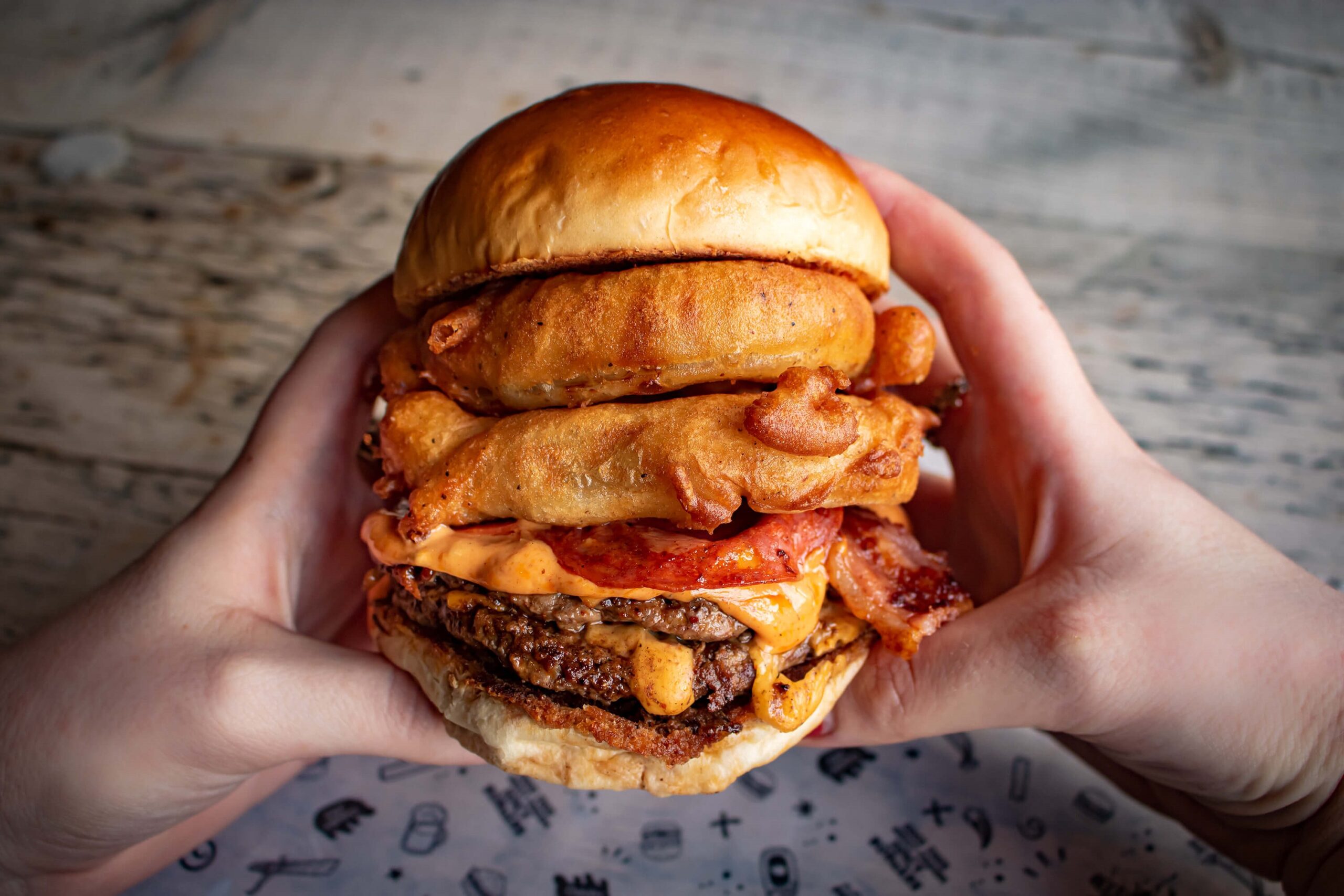 hands holding a beef burger from Fat Hippo