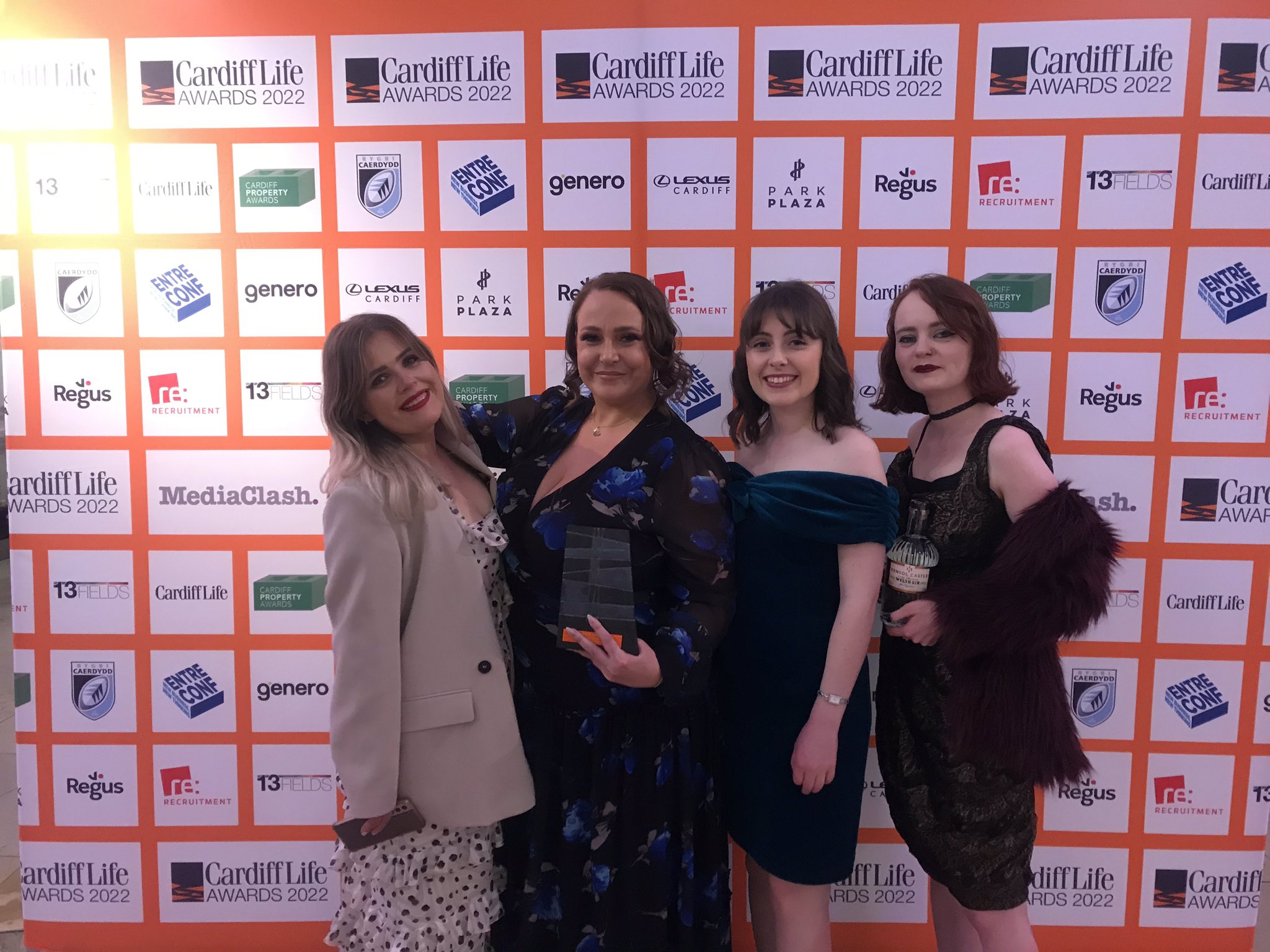 four FOR Cardiff employees standing holding the award and smiling