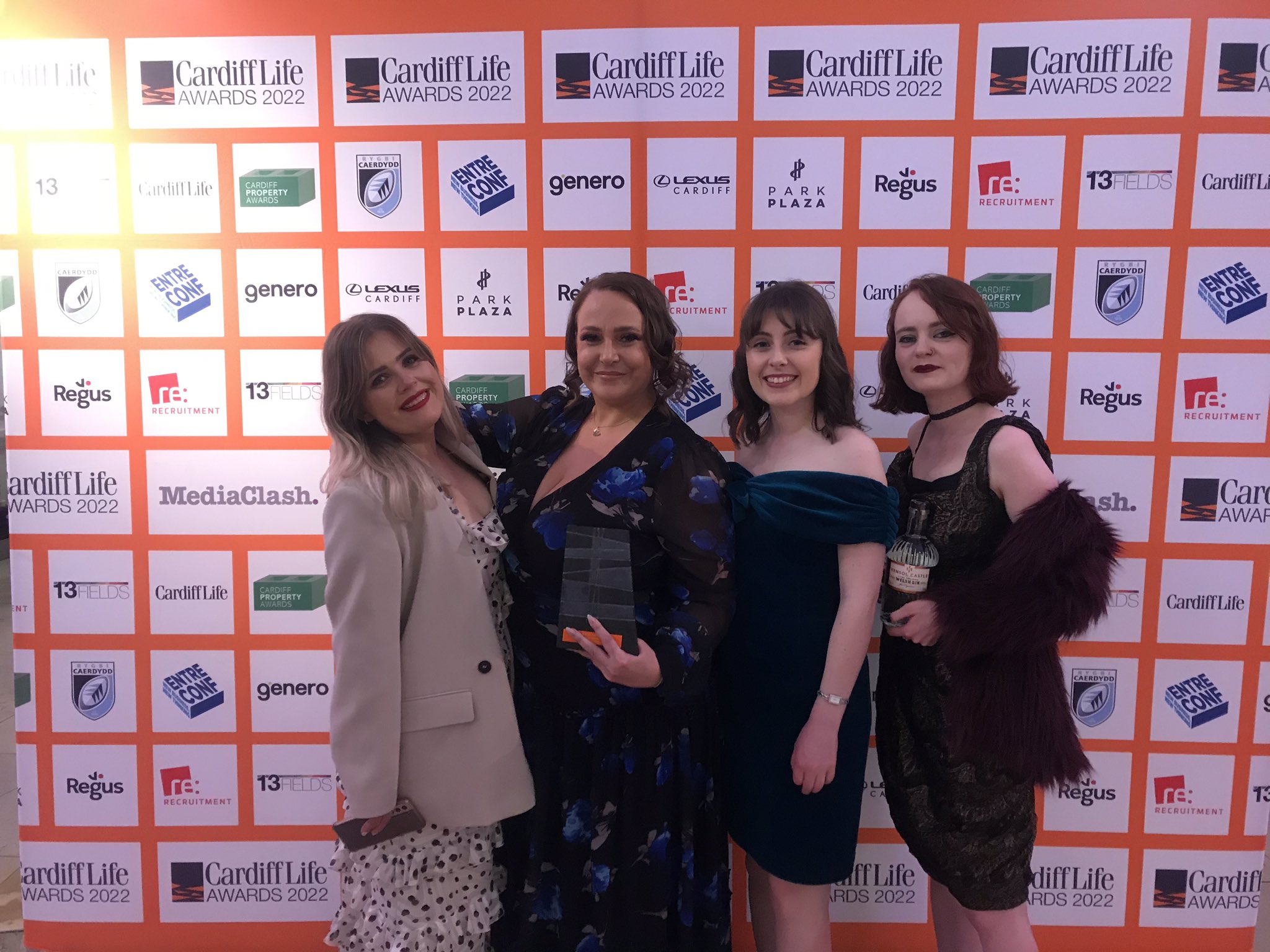 four FOR Cardiff employees standing holding the award and smiling
